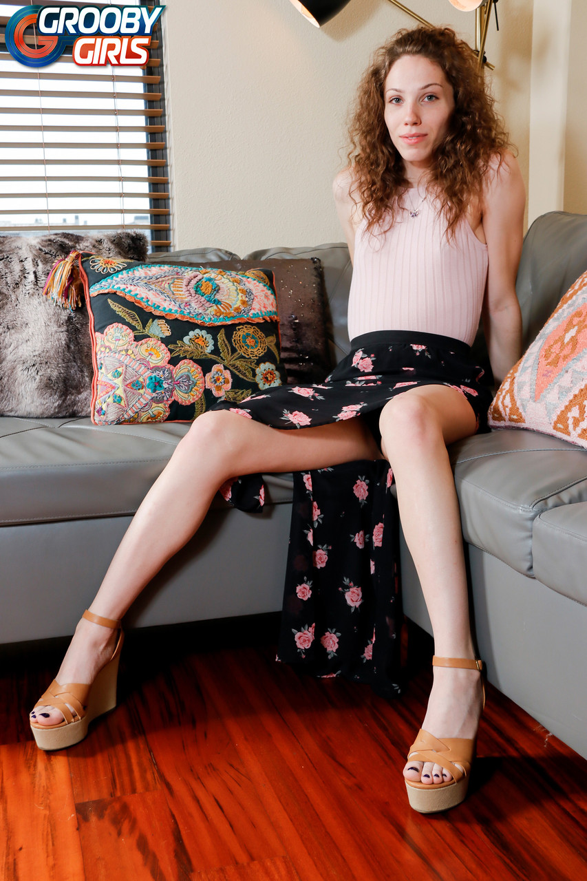 Curly-haired shemale Belle Adams doffs her clothes & teases