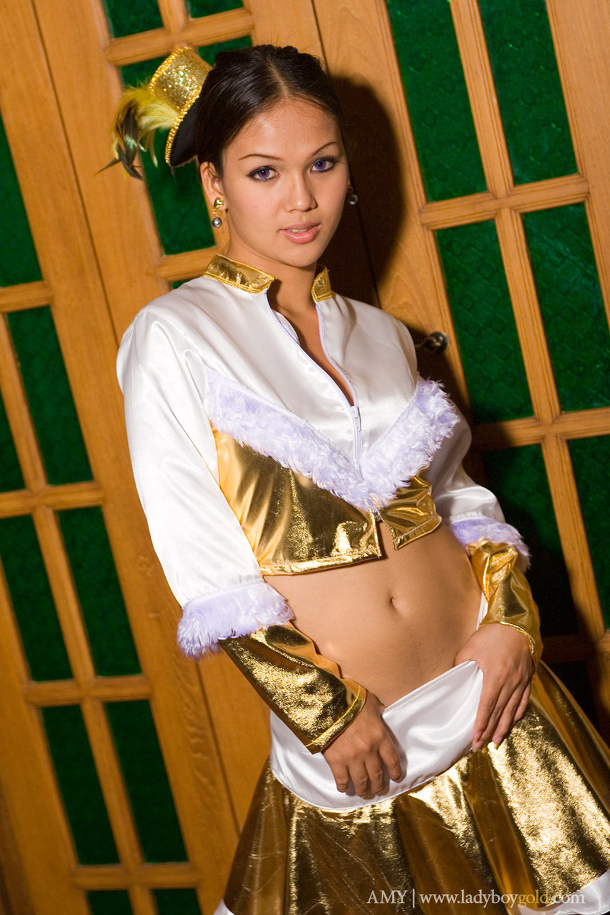 Asian shemale Amy undresses golden outfit and teases