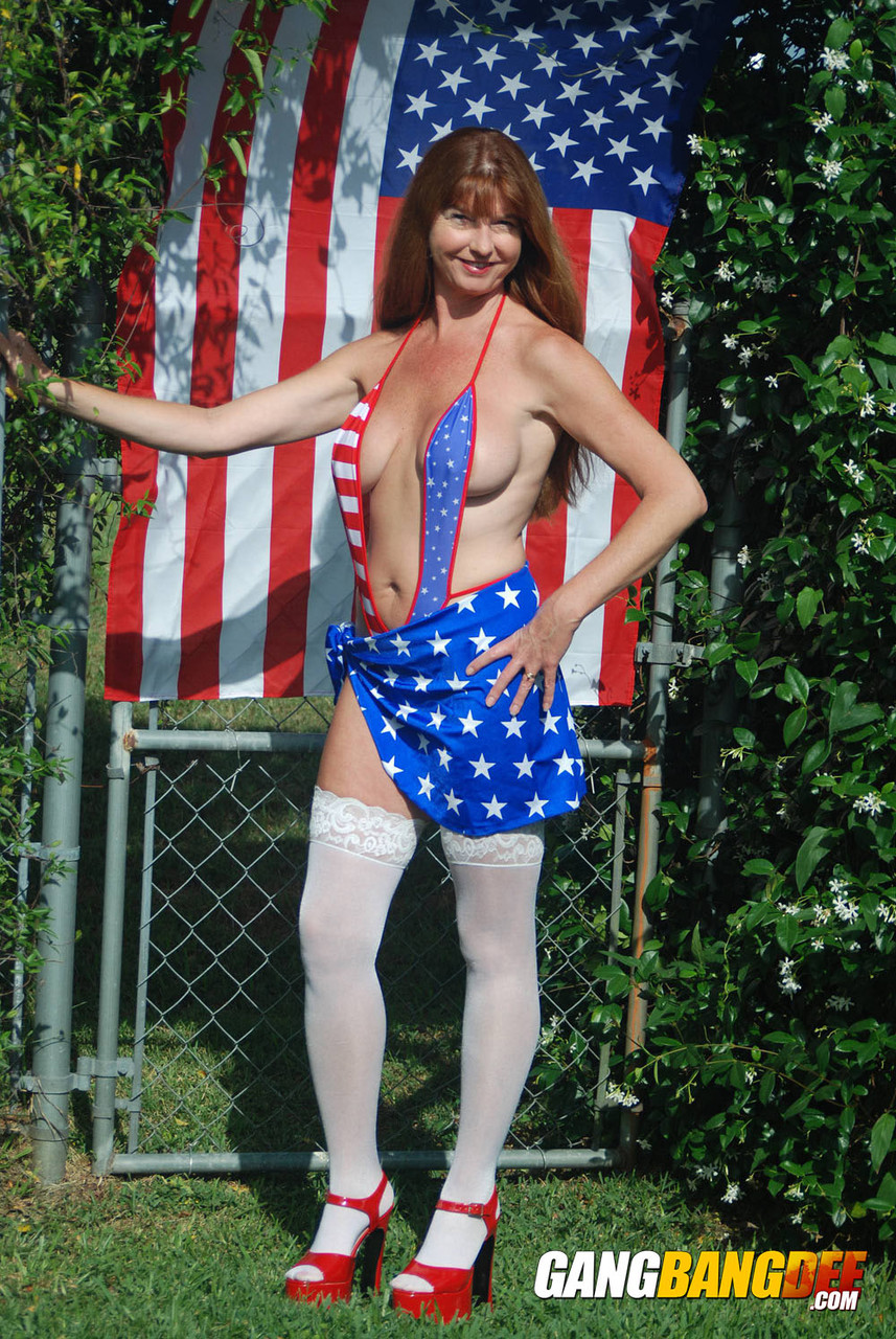 Hot mature Dee Delmar in patriotic swimsuit flaunting firm big tits in the sun