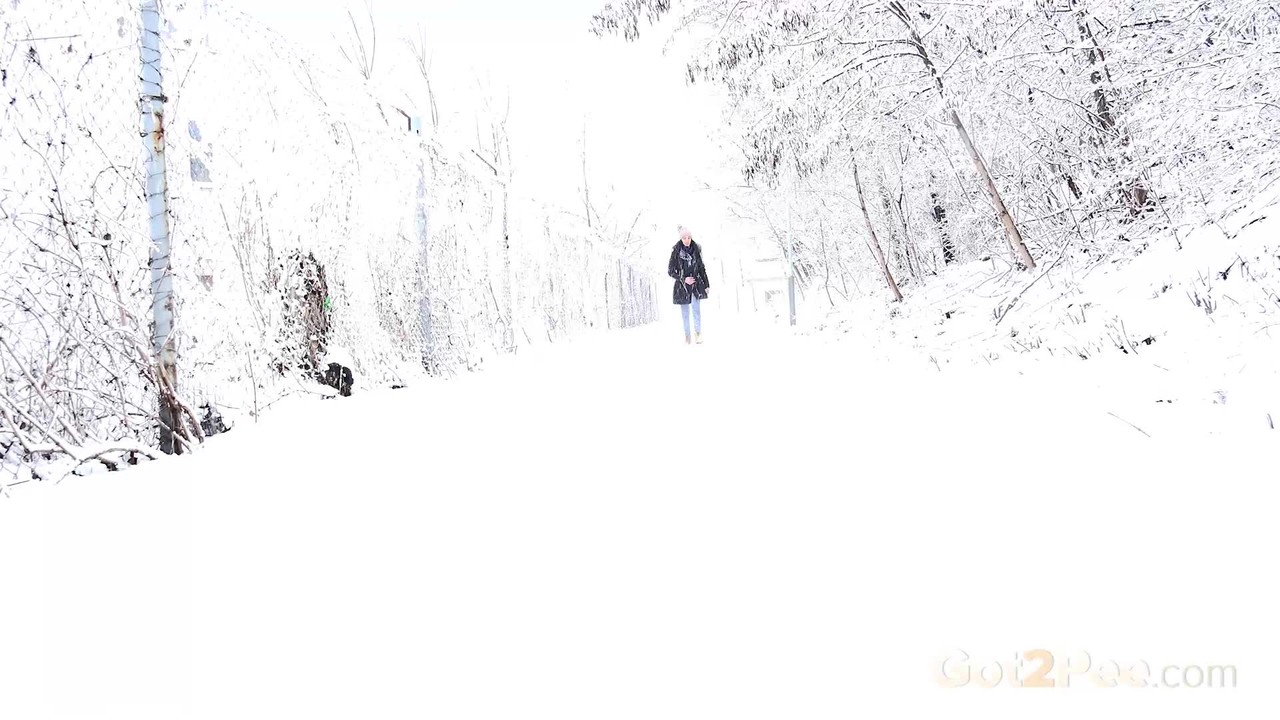 Caucasian girl Esperansa pulls down her jeans to pee on snow laden ground