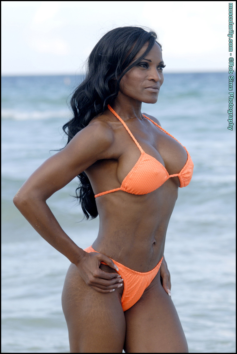 Ebony bodybuilder Debra Dunn poses at the ocean in a string bikini  