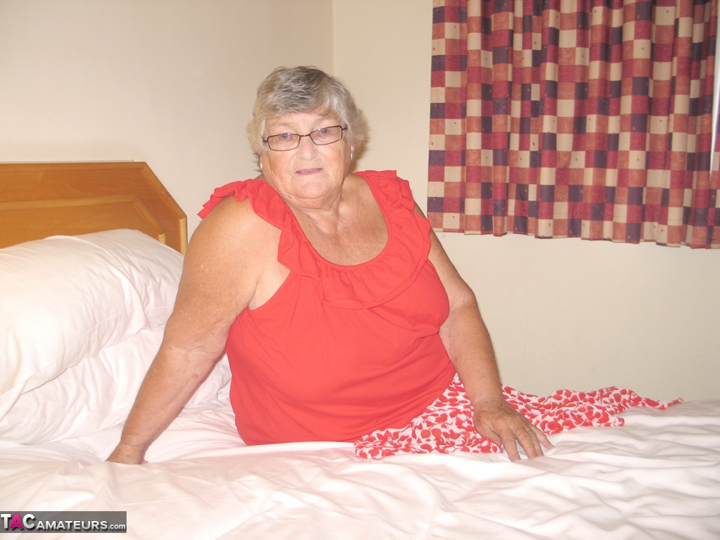 Fat British lady Grandma Libby toys her pussy on a bed in nylons and garters