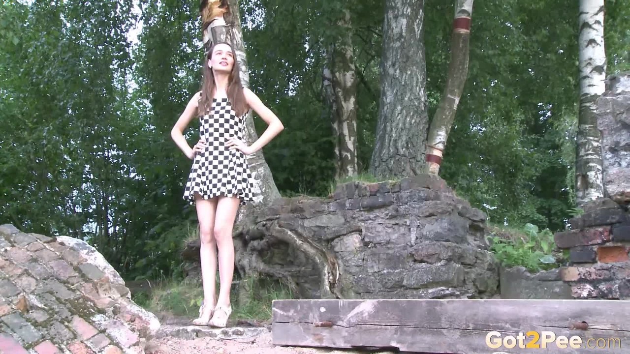 Distressed teen Oksana lifts up a checkerboard dress for an urgent pass