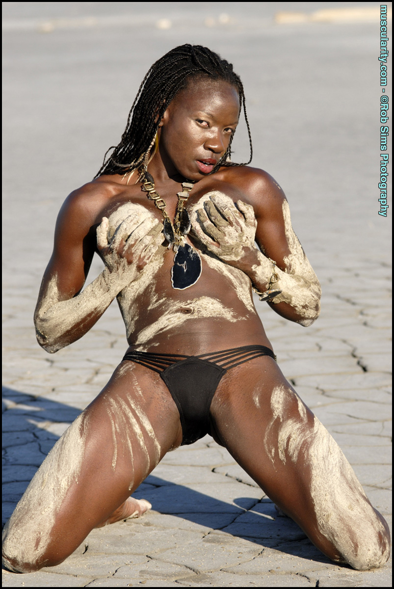 Ebony bodybuilder Camille Elizabeth covers her toned body in beach sand  