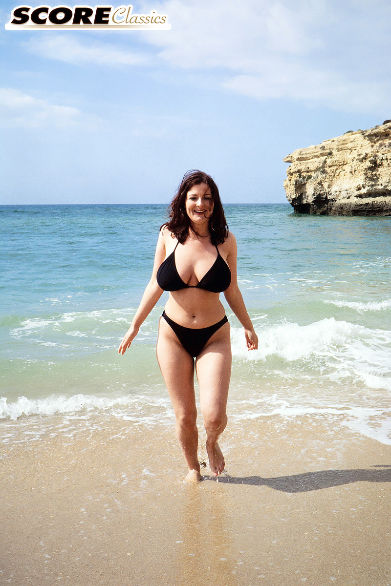 Brunette MILF Lorna Morgan releases her nice melons from bikini on a beach  