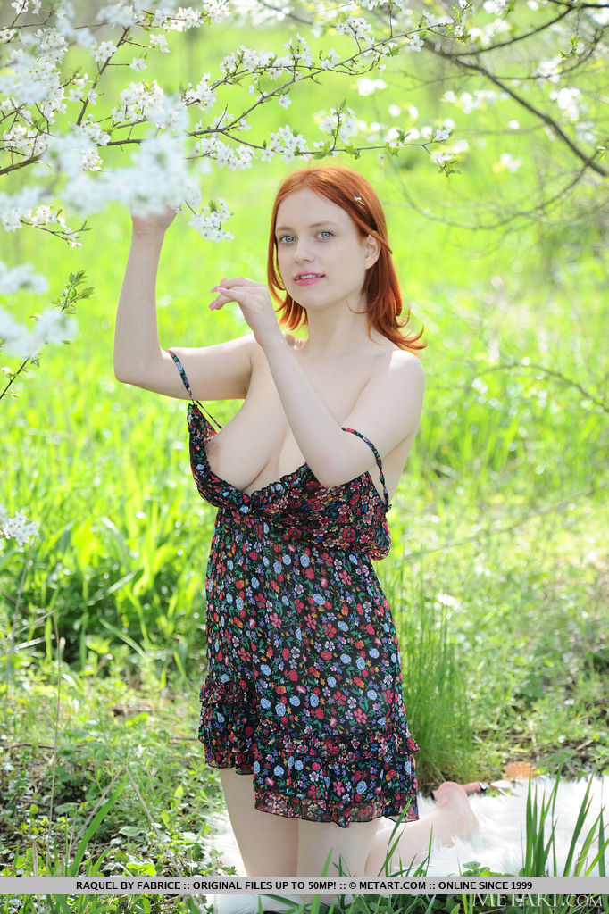 Pale redhead Raquel gets totally naked underneath a flowering tree  