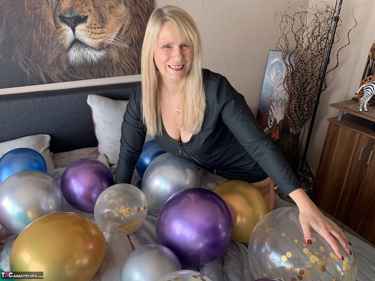 Middle-aged blonde Sweet Susi gets naked on her bed amid balloons  