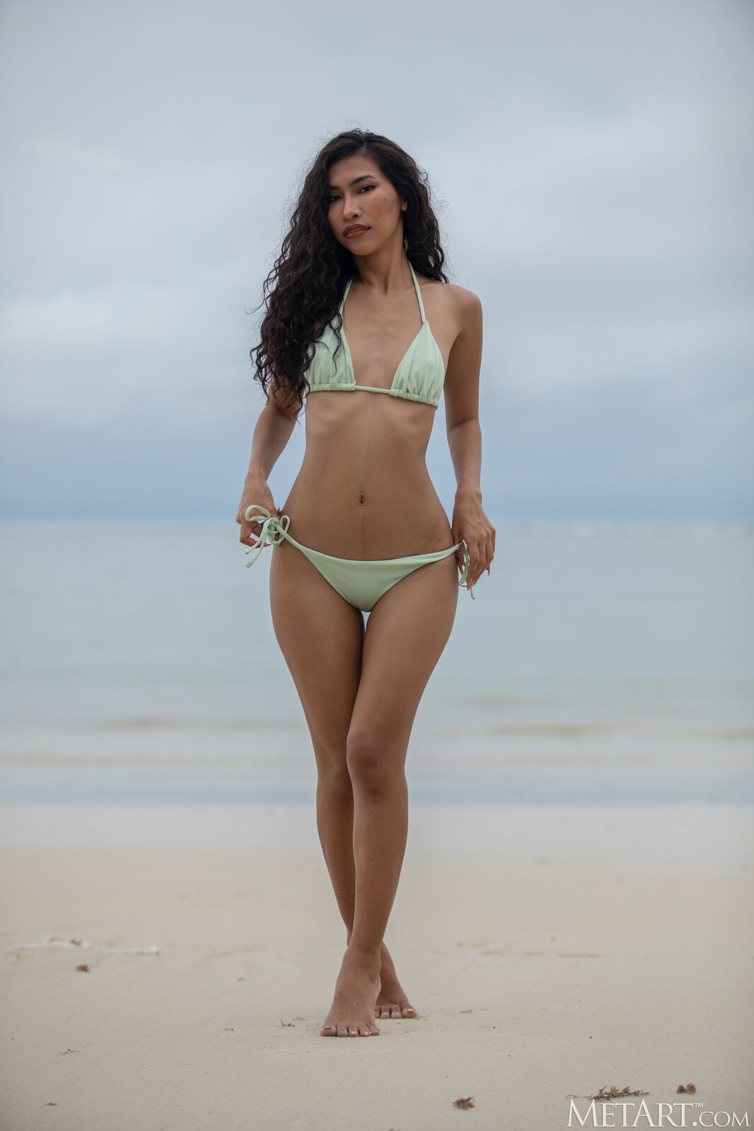 Beautiful nude Thai model Niki peeling off bikini on the beach